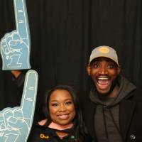 two people smiling and holding up foam fingers